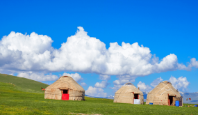 Yurtas Tradicionales De Kirguistán En Las Praderas Verdes Del Lago Son Kul Bajo Un Cielo Azul Con Nubes.