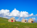 Yurtas Tradicionales De Kirguistán En Las Praderas Verdes Del Lago Son Kul Bajo Un Cielo Azul Con Nubes.