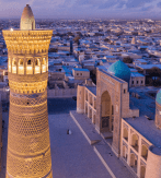 Vista Aérea Del Minarete Kalyan Iluminado Junto A Las Cúpulas Turquesas Del Complejo Po-i-Kalyan En Bujará, Uzbekistán, Al Atardecer